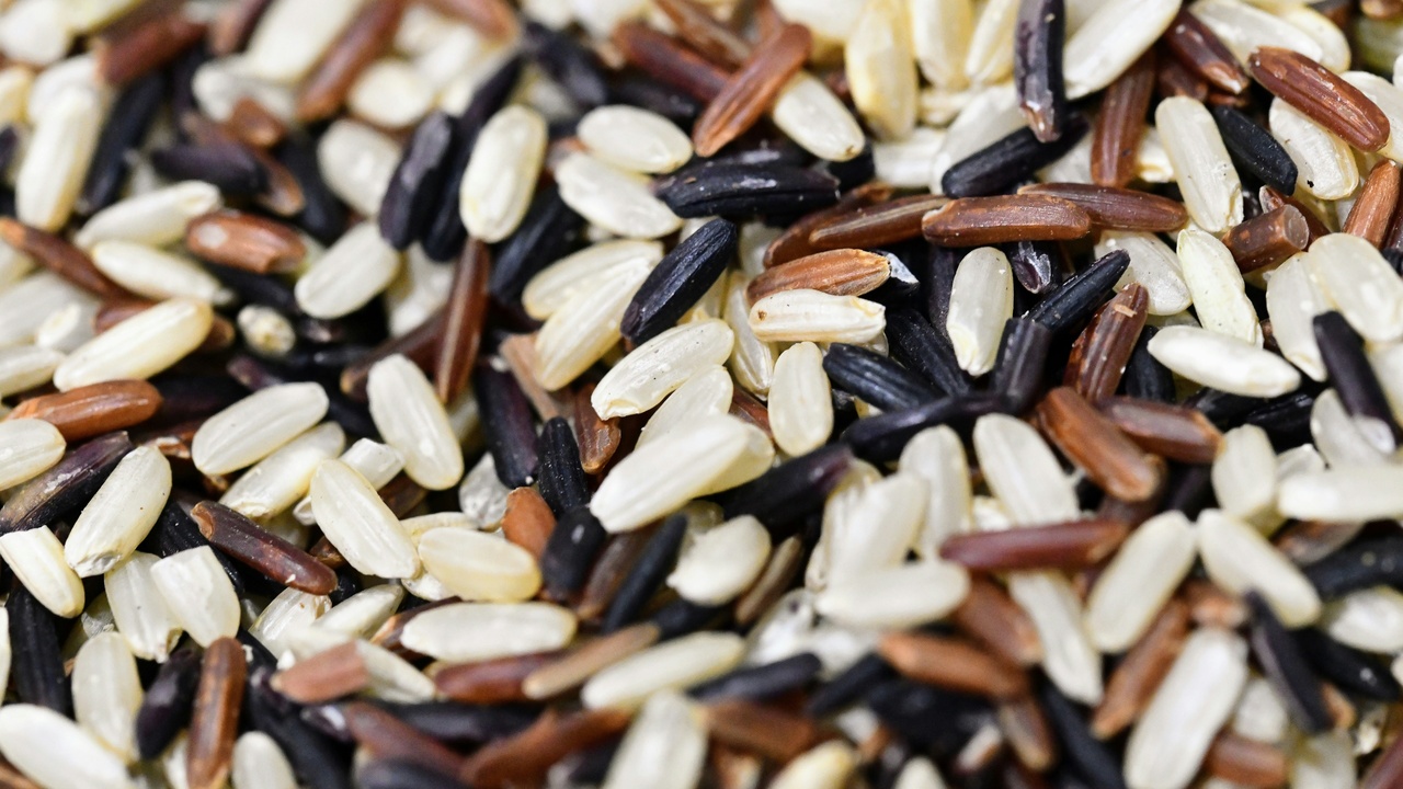 Nutritional comparison chart for cooked wild rice and white rice with measuring spoons