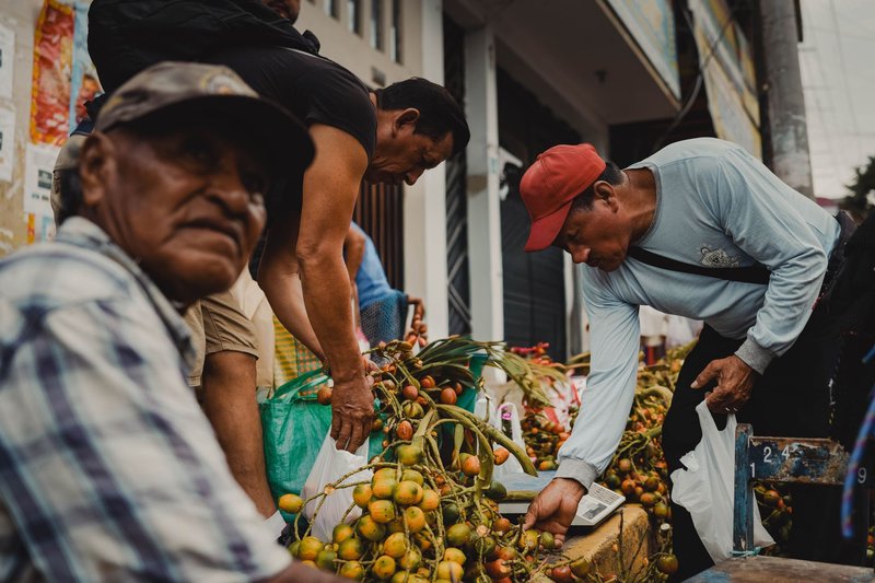 Rural Peruvian market with local men selling fresh produce outdoors.