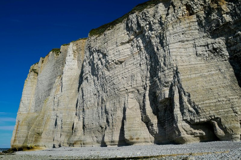 Stunning limestone cliffs with rugged texture against clear blue sky, showcasing natural beauty and rocky formations.