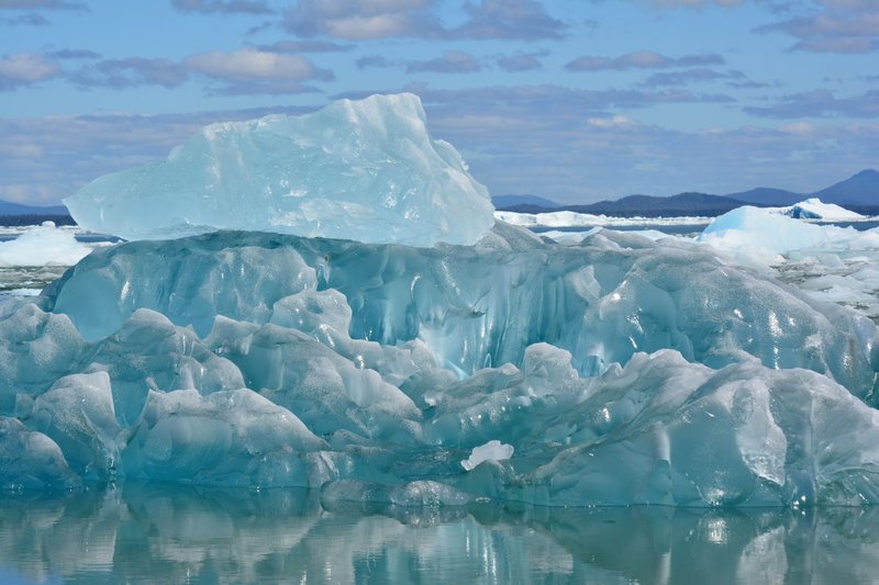 Stunning iceberg captured in clear Arctic waters, highlighting melting ice and climate change impact.