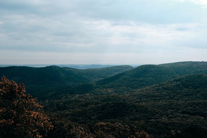 A breathtaking aerial view showcasing lush green mountain landscapes under a vibrant sky.