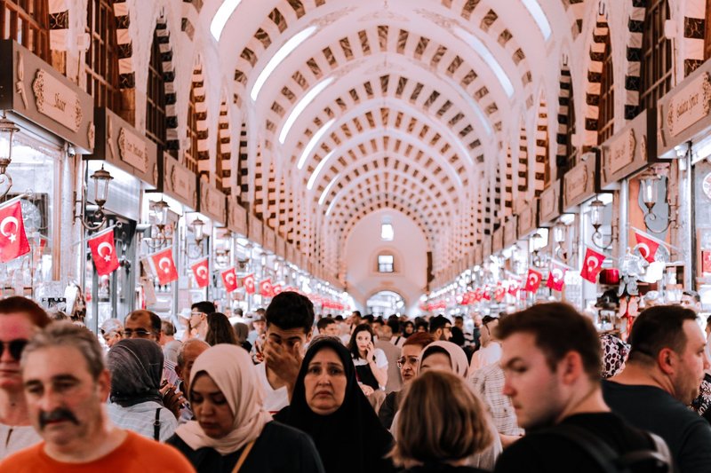 Bustling scene in Istanbul's historic Spice Bazaar, filled with diverse shoppers and vibrant colors.