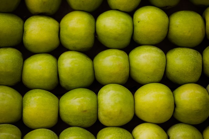 Vibrant green apples neatly arranged in rows, showcasing freshness and nutritional value.