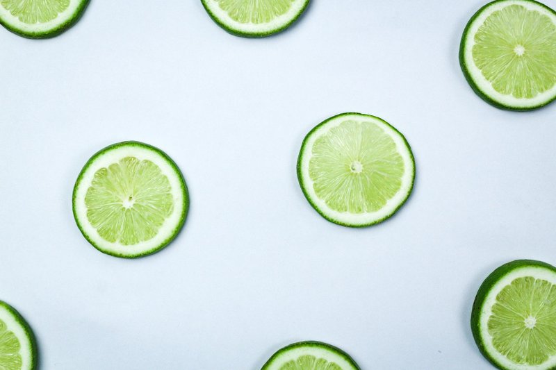 Bright lime slices arranged on a white surface, showcasing their refreshing appeal.