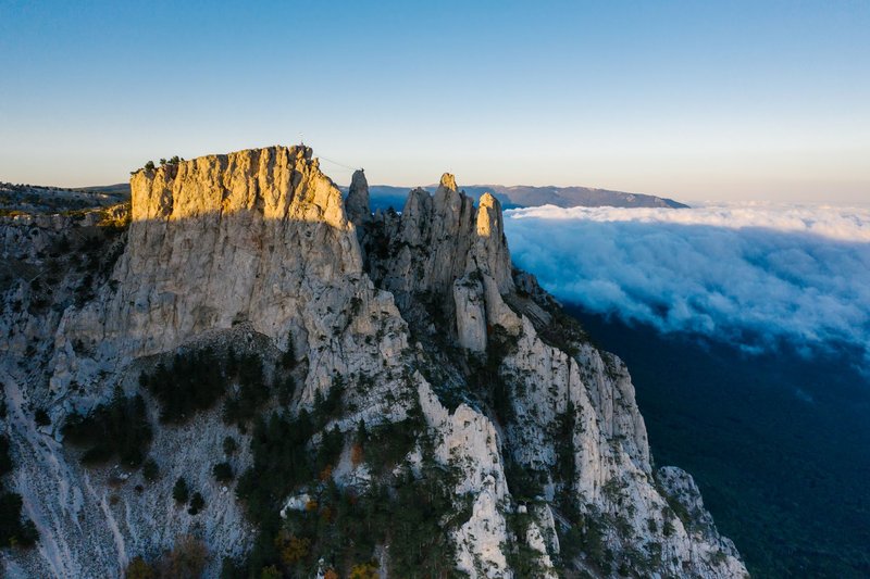 A stunning rocky mountain landscape with clouds enveloping the peaks, capturing a picturesque scenic view.