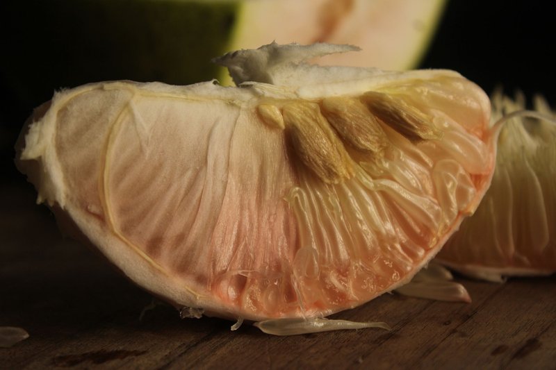 Detailed shot of a ripe pomelo section showing its juicy texture and seeds.